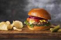 Cheeseburger, cornichons et chips — Photo de stock