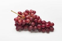 Червоний виноград на білій поверхні — стокове фото