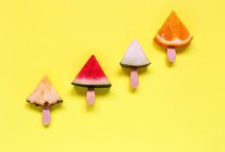 Nahaufnahme von verschiedenen aufgeschnittenen Früchten auf einer gelben Oberfläche — Stockfoto