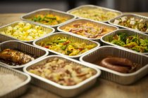 Elevated view of assorted ready meals in aluminium containers — Stock Photo