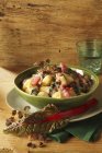 Gnocchi with colourful chard on green plate over wooden surface — Stock Photo