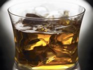 Closeup view of Bourbon with ice cubes in glass — Stock Photo