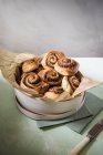 Elevated view of cinnamon swirls with a pecan nut filling in a wooden box — Stock Photo