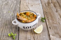 Prawn and vegetable soup over wooden surface — Stock Photo