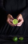 Female hands holding half of lime — Stock Photo