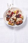 Вид крупным планом ломтиков дрожжевой пекарни с ягодами на тарелке — стоковое фото
