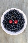 Blueberries and pair of cherries — Stock Photo