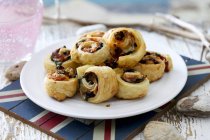 Puff pastry swirls with a vegetable filling on white plate — Stock Photo