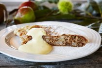Груша и орех Studel с zabaione на белой тарелке — стоковое фото