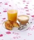 Cappuccino mit Croissant und Orange — Stockfoto