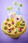 Vista ravvicinata di pasticcini e quattro petits con fiori sullo stand — Foto stock