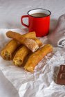 Closeup view of Churros and coffee on creased paper — Stock Photo