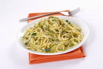 Espaguetis de trigo de Jorasán con cebolla de primavera - foto de stock