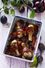Chicken drumsticks with bacon and plums — Stock Photo