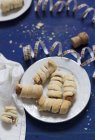 Elevated view of sausages wrapped in puff pastry with party decorations — Stock Photo