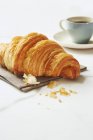 Croissant with an espresso cup — Stock Photo