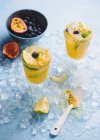 Primo piano delle bevande all'arancia con frutto della passione, lime e mirtilli — Foto stock