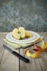 Разрезанное пополам яблоко на тарелке — стоковое фото