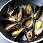 Closeup view of opened mussels in sauce — Stock Photo