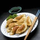 Vue rapprochée des Potstickers asiatiques frits avec une trempette — Photo de stock