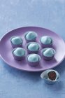 Closeup view of blue truffles on lilac plate — Stock Photo