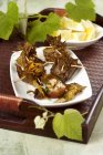 Funghi in foglie di vite su piastra bianca su vassoio — Foto stock