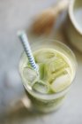 Vue rapprochée du Matcha latte avec glaçons et paille en verre — Photo de stock