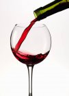 Rotwein wird in ein Glas gegossen — Stockfoto