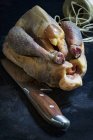 Вид крупным планом сырой гвинейской птицы с ножом и кухонной ниткой — стоковое фото