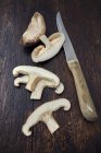 Крупним планом нарізаний гриб Шиїтаке з ножем на дерев'яній поверхні — стокове фото