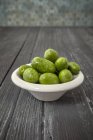 Rohe grüne Oliven in Schüssel — Stockfoto