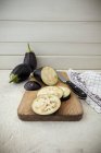 Aubergine sliced into round disks on a chopping board — Stock Photo