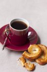 Baked palmiers and cup of coffee — Stock Photo