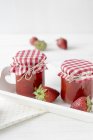 Jars of strawberry jam on tray — Stock Photo