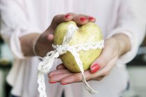 Une femme mains tenant une pomme de terre en forme de cœur, section médiane — Photo de stock