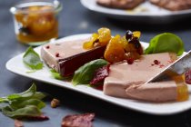 Closeup view of liver pate slices with leaves and preserved fruit — Stock Photo