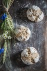 Healthy wholemeal buns with ears of oat and flowers on a wooden board — Stock Photo