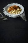 Closeup view of paprika chicken with dumplings on black surface — Stock Photo