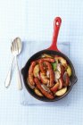 Sausages with apples and shallots — Stock Photo