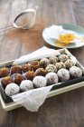 Vue rapprochée de truffes à boule assorties sur papier en boîte — Photo de stock