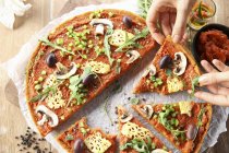 Mujer comiendo pizza vegana con piña - foto de stock