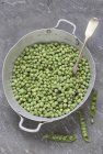 Fresh peas in old saucepan — Stock Photo