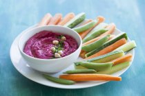 Beetroot hummus on white plate with bowl — Stock Photo