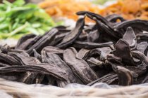 Closeup view of dry carob pods in a basket — Stock Photo