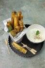 Baked light zucchini stick whit yogurt sauce over tray — Stock Photo