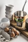 Elevated view of eggs with salt, chives, dishes and a copper saucepan — Stock Photo