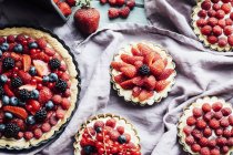 Крупный план различных ягодных пирогов на ткани — стоковое фото