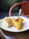 Nahaufnahme einer spanischen Tortilla mit Brot und Gabel auf dem Teller — Stockfoto