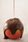 Coating apple with melted chocolate — Stock Photo