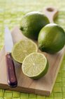 Fresh ripe Limes with halves — Stock Photo